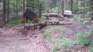 Advance planning will allow arranging logs in a manner to more easily load the sawmill.  Creating a cut bank or using a gentle slope makes easy work of loading logs if the sawmill lack hydraulics.