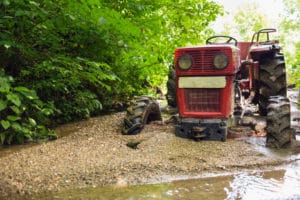 Tractor stuck in the mud on a river.