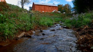 creek in front of red barn