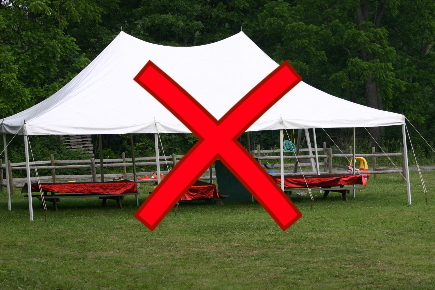 Picnic tables under tent with red x through image