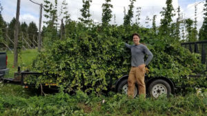 Smart Farming Team participants and Bineyard owner, Chad Meigs poses with a beautiful hop harvest.
