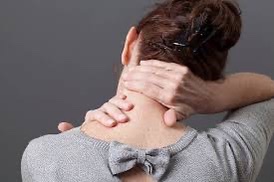 A person uses their own hands to massage their neck and shoulder