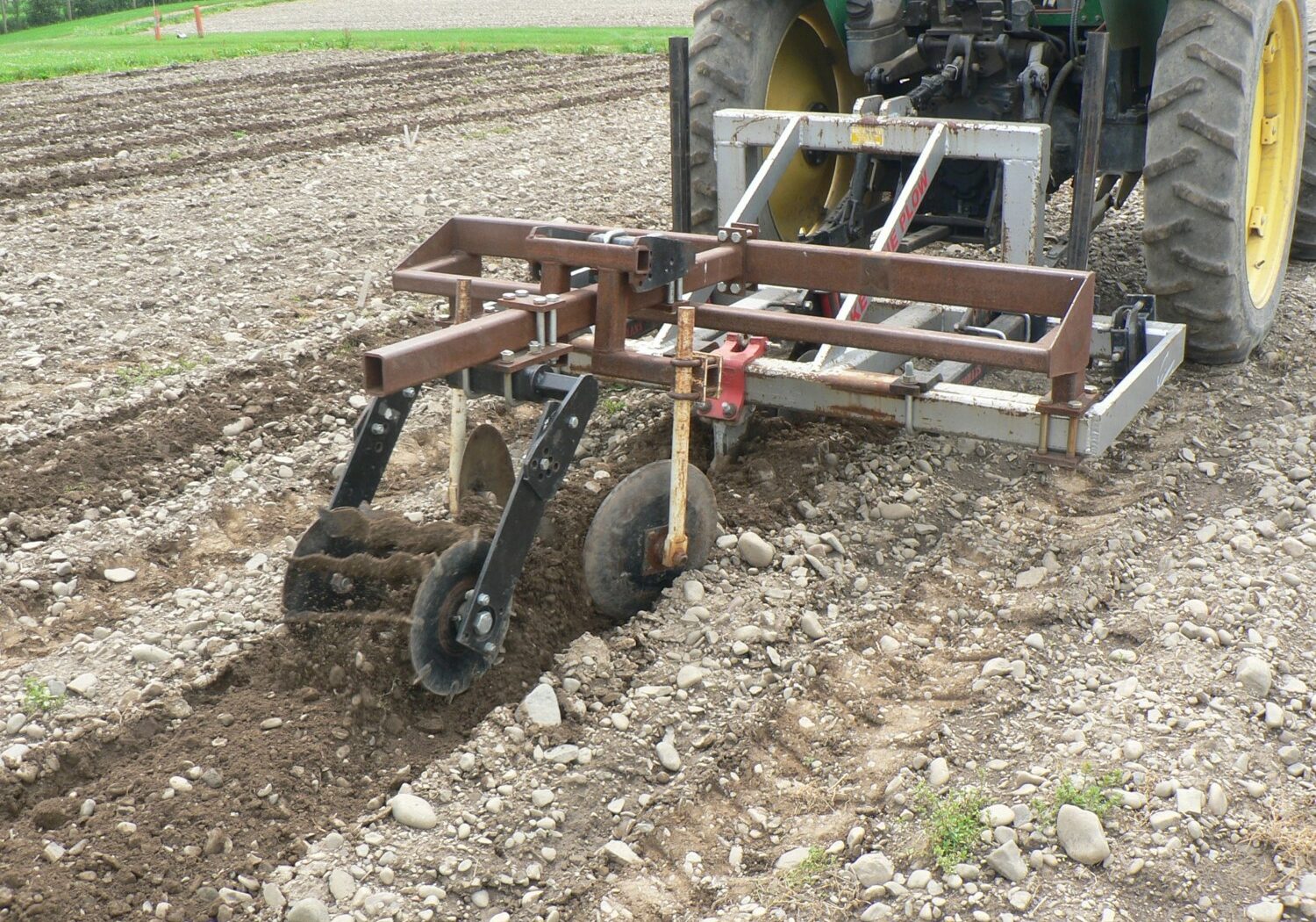 Yeomans Plow with a custom-built hilling discs and rolling basket attachments preparing the planting zone. 